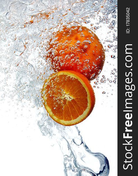 Fresh oranges dropped into water