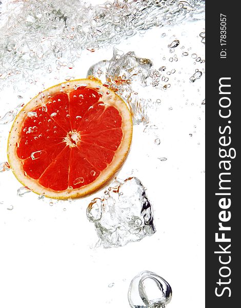 Fresh grapefruit dropped into water