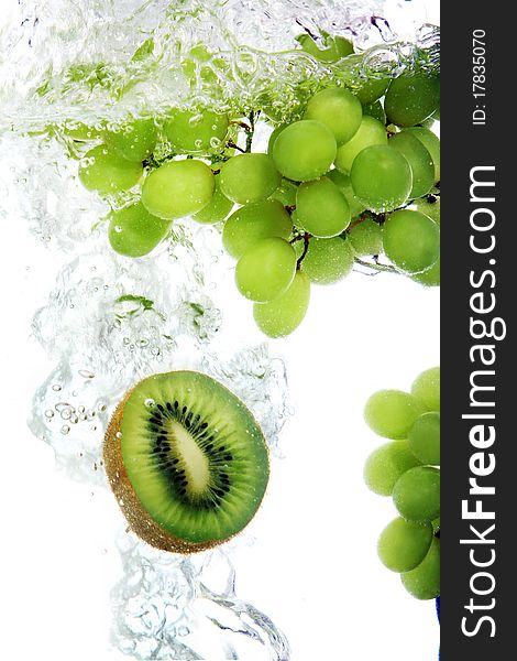 Kiwi and grape dropped into water