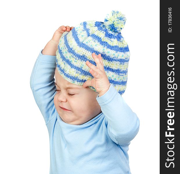 Angry baby taking off a wool cap isolated on white background