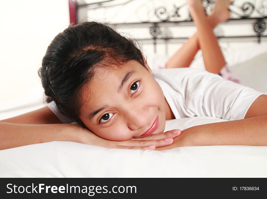 Close up picture of a young happy girl on bed