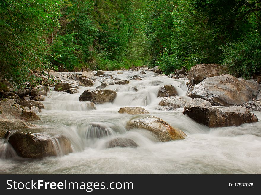 View on waterfall cascade in green forest