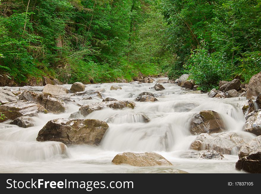 View on waterfall cascade in green forest