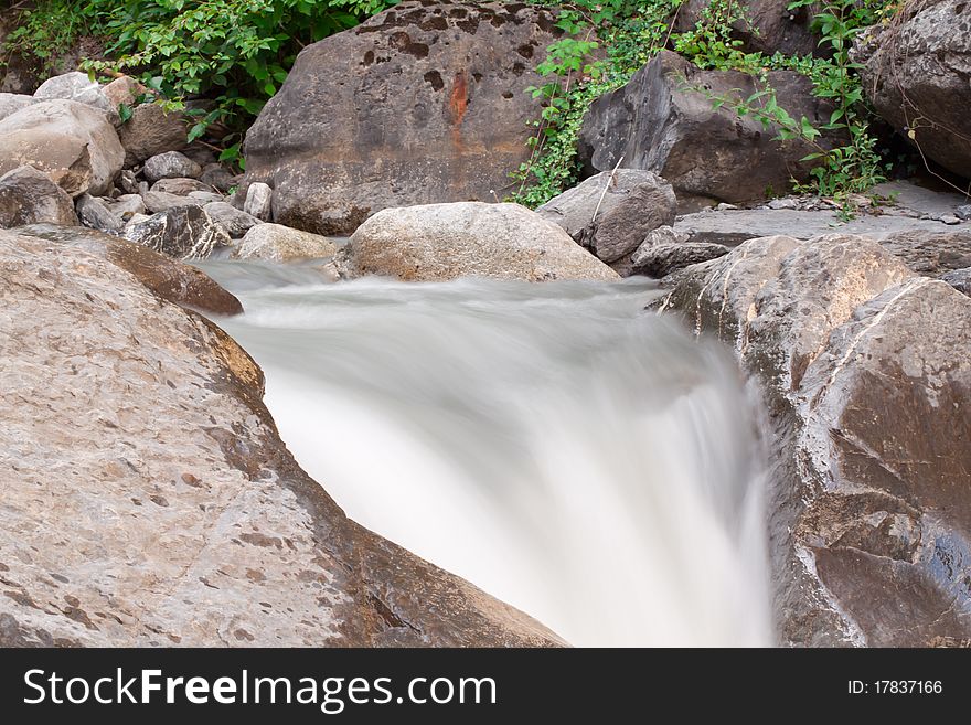 View on waterfall cascade in green forest