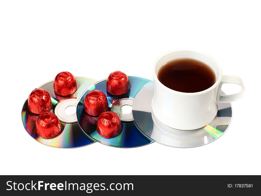 A cup of tea with sweets on CDs. Isolated on white background. A cup of tea with sweets on CDs. Isolated on white background.