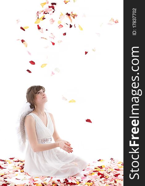 Girl in white dress and wings throwing petals