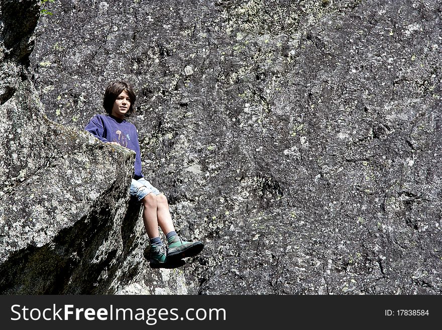 Boy sitting among the rocks