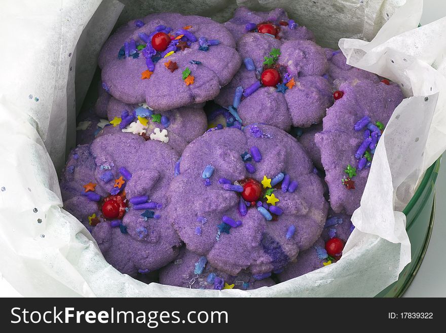 Purple spritz cookies in a tin