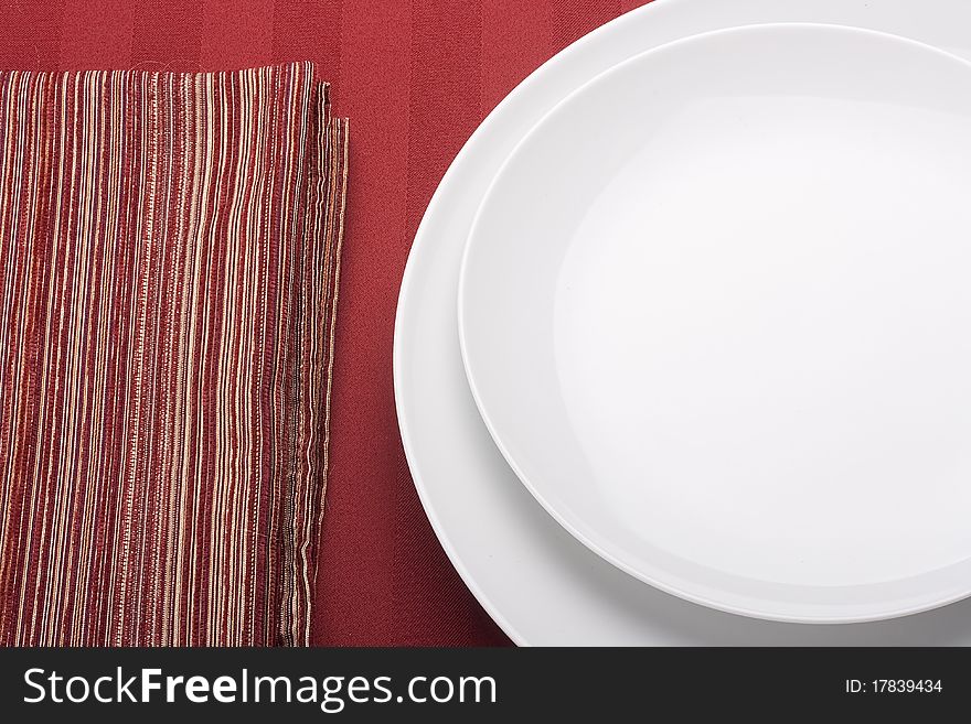 White plate on a red background with a red cloth.