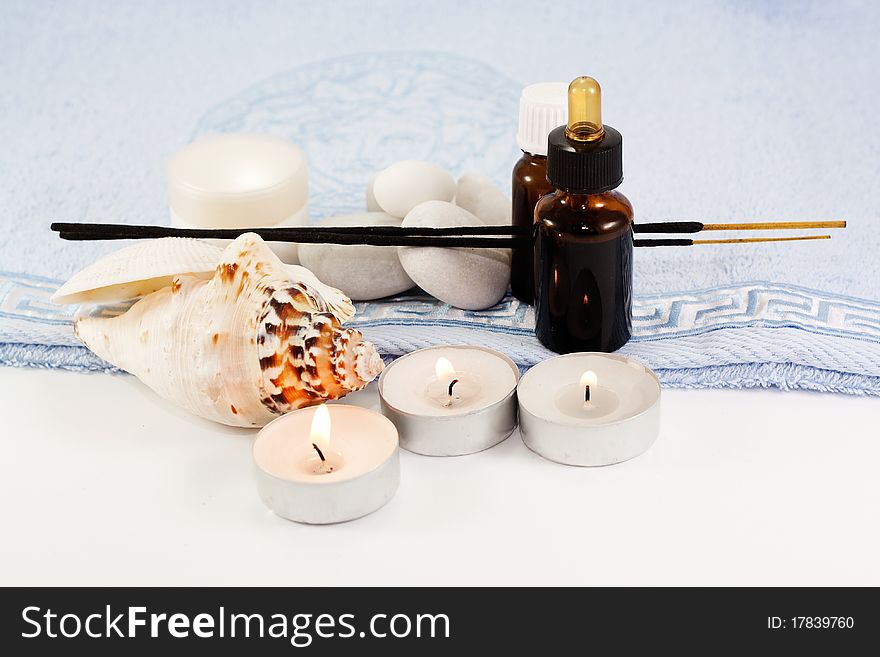 Essential oils, body lotion, candles, shells and sea stones on a towel. Essential oils, body lotion, candles, shells and sea stones on a towel