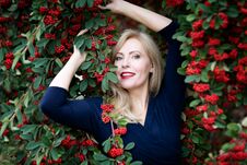 A Waist Up Portrait Of Caucasian Woman With Long Blond Hair With Red Near A Bush With Red Berries Royalty Free Stock Image