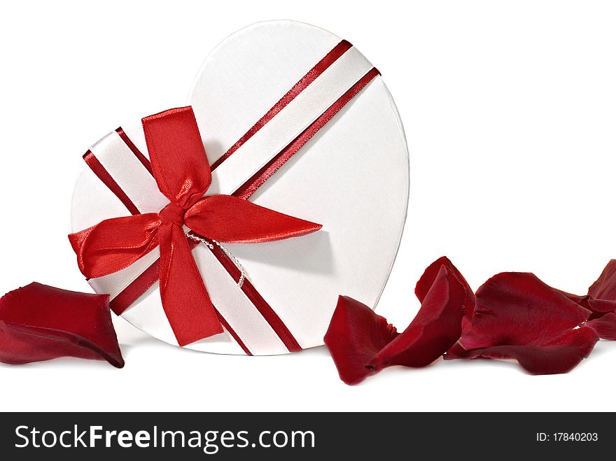 Gift box in shape heart with petals of roses on a white background