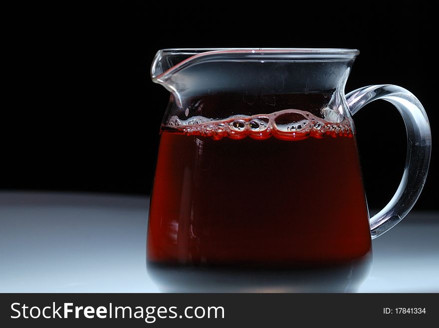 A glass is full of tea with black background. A glass is full of tea with black background.