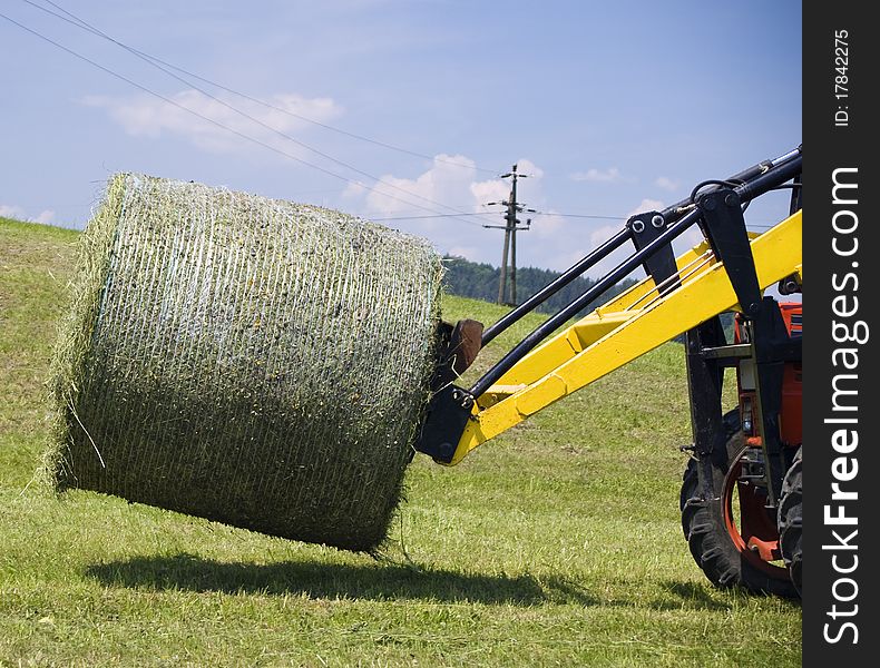 Detail view of a Tractor working with a Hay Bale