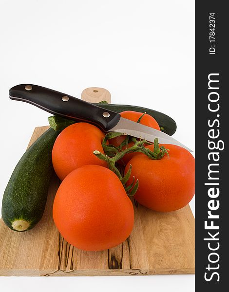 Tomato and courgette with knife on wodden table