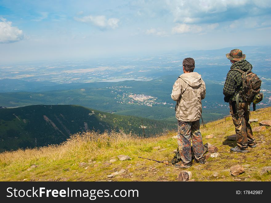 Hiker on a peak enjoys mountain landscape