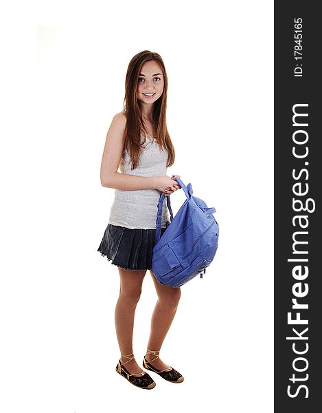 A pretty teenager in a short skirt and a blue backpack in her hand, standing in the studio for white background. A pretty teenager in a short skirt and a blue backpack in her hand, standing in the studio for white background.