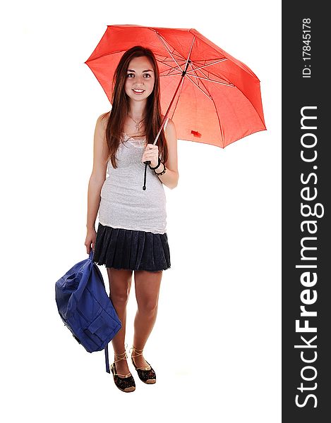 A pretty teenager in a short skirt and a blue backpack in her hand and an open umbrella over her shoulder standing in the studio for white background. A pretty teenager in a short skirt and a blue backpack in her hand and an open umbrella over her shoulder standing in the studio for white background.