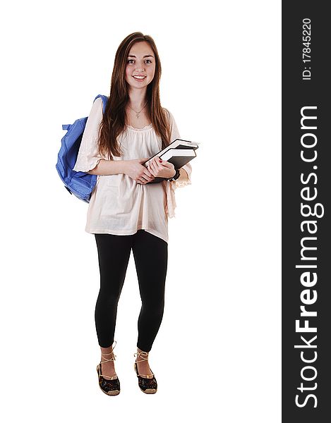 A pretty teenager in black tights and a blue backpack over her shoulder and books in her hand, standing in the studio for white background. A pretty teenager in black tights and a blue backpack over her shoulder and books in her hand, standing in the studio for white background.