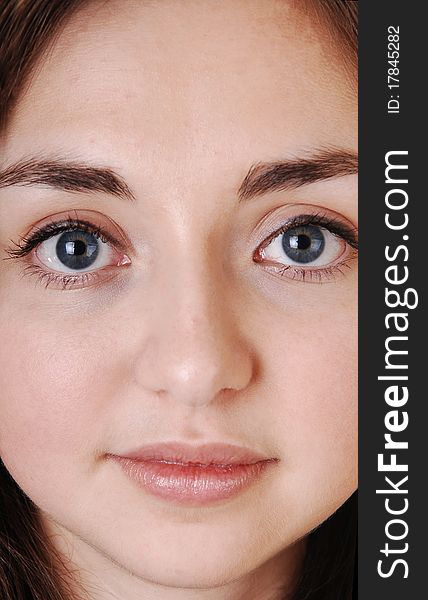 A closeup of a beautiful face of a young girl with blue eyes and brunette hair, looking strait into the camera. A closeup of a beautiful face of a young girl with blue eyes and brunette hair, looking strait into the camera.