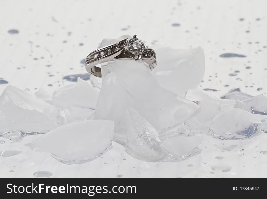 White Gold diamond engagement ring on ice cubes against a white background