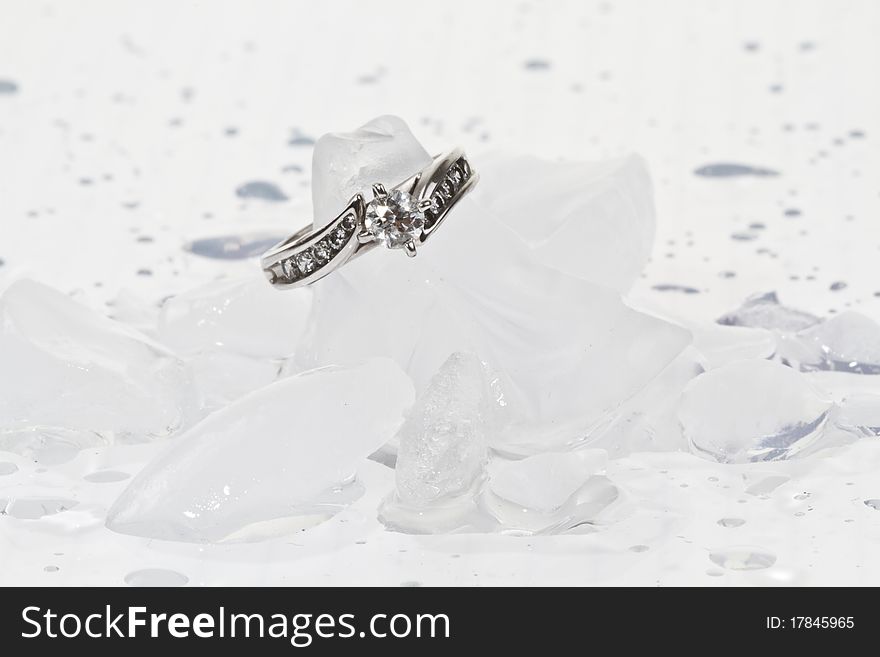 White Gold diamond engagement ring on ice cubes against a white background