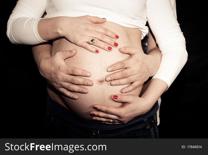Pregnant belly with four hands. Pregnant belly with four hands