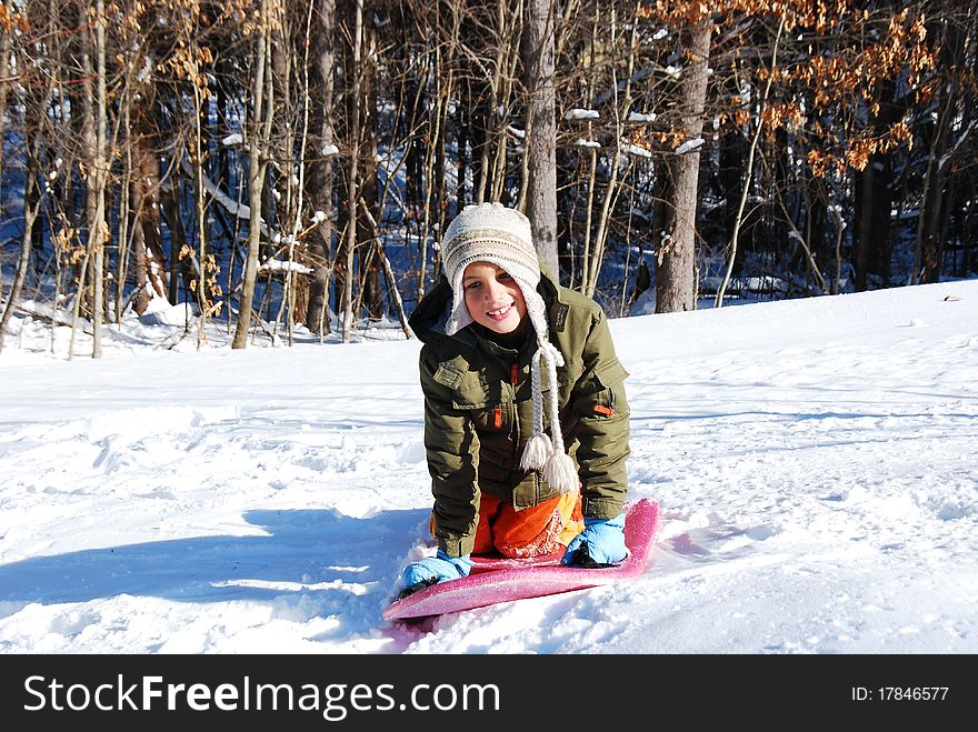 A young boy plays in the snow on a sunny winter afternoon. A young boy plays in the snow on a sunny winter afternoon