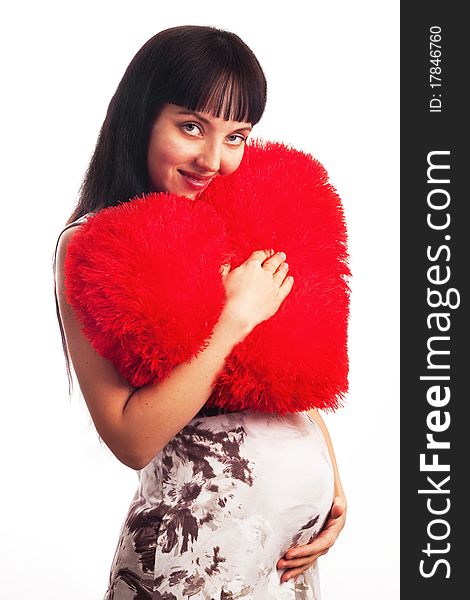 Young pregnant girl hugging a soft big heart