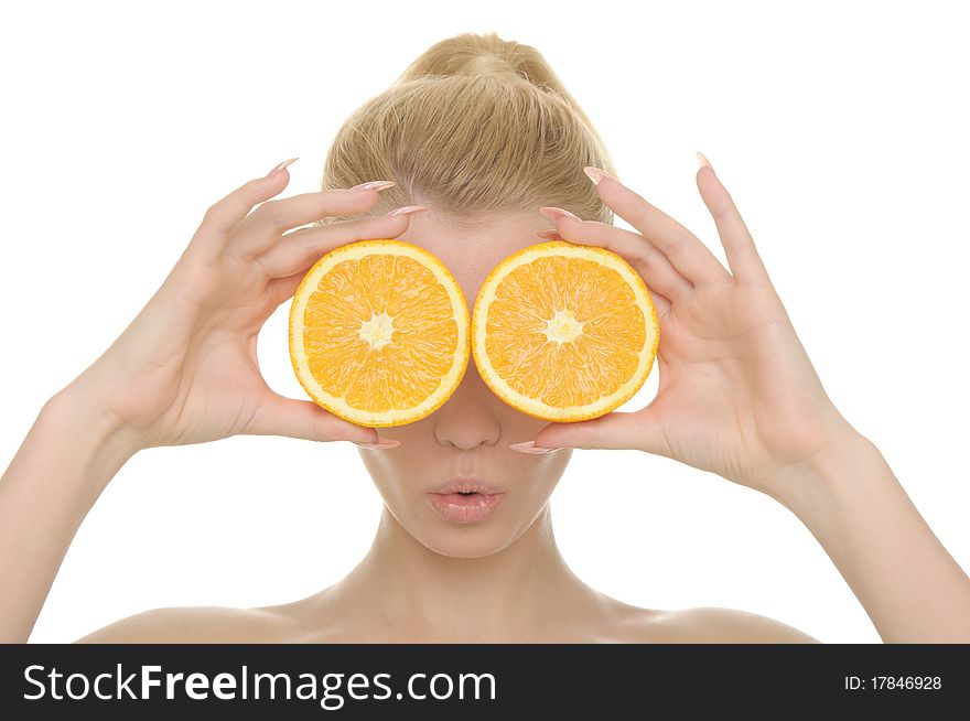 Young woman holds halves of oranges before eyes isolated in white