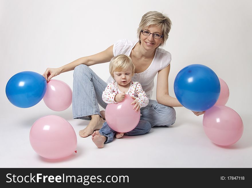 Portrait of cute girl with her mother with pink and blue balloons having fun at the party. Portrait of cute girl with her mother with pink and blue balloons having fun at the party