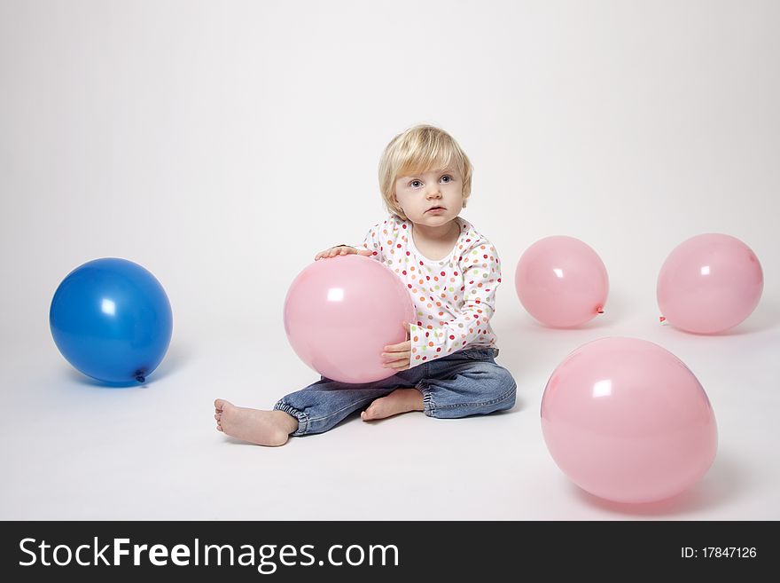 Portrait of cute girl with pink and blue balloons having fun at the party