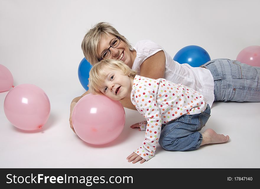 Portrait of cute girl with her mother with pink and blue balloons having fun at the party. Portrait of cute girl with her mother with pink and blue balloons having fun at the party