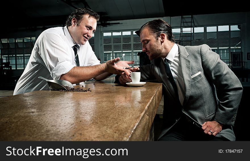 Barista shows customer the coffee bean he is drinking. Barista shows customer the coffee bean he is drinking