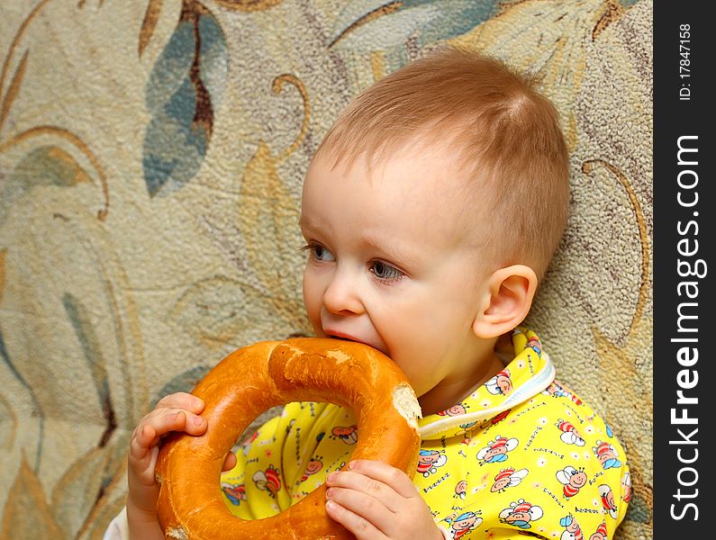 Little boy in yellow shirt who eats a bagel. Little boy in yellow shirt who eats a bagel