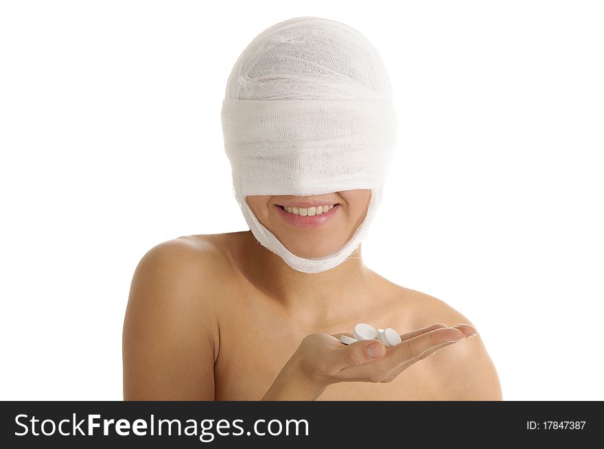 Young woman with bandaged head with tablets on palm isolated in white
