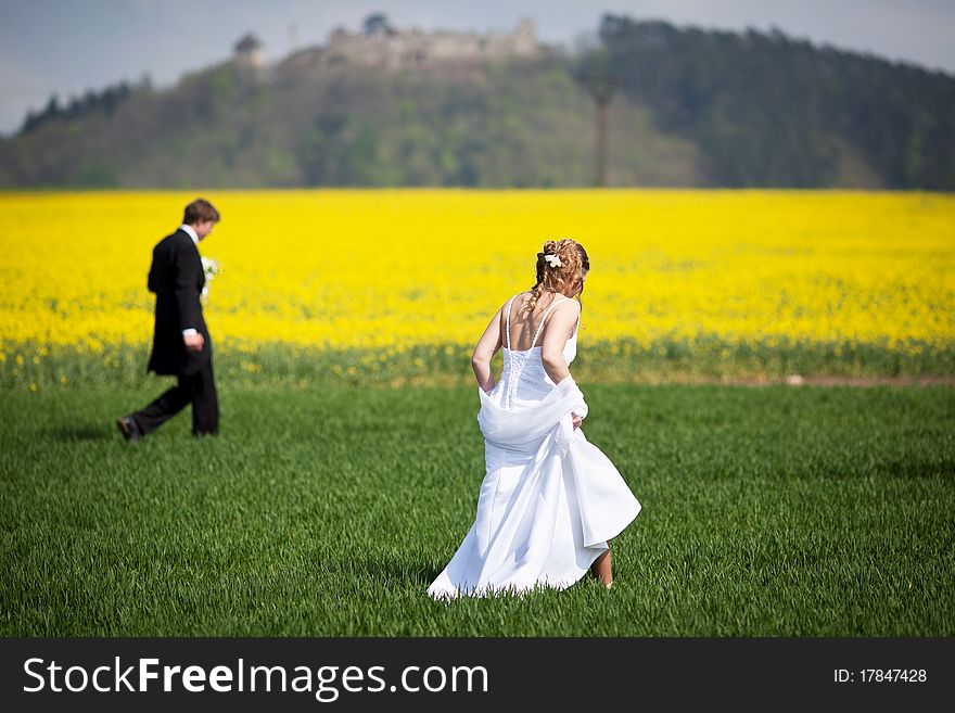 Young wedding couple - freshly wed groom and bride posing outdoors on their wedding day