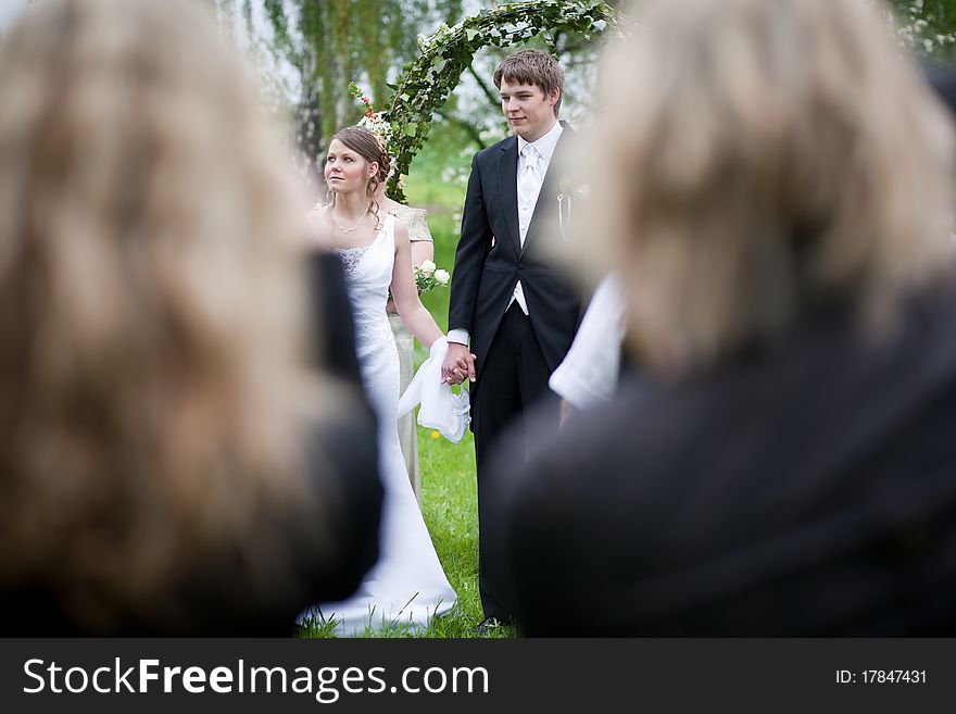 Young wedding couple - freshly wed groom and bride posing outdoors on their wedding day