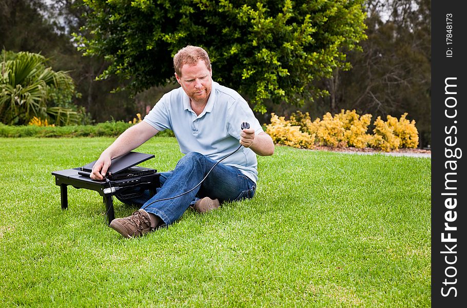 Man With Laptop Wondering Where To Plug In