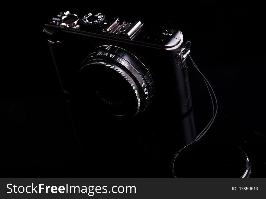 Black digital camera on dark backround