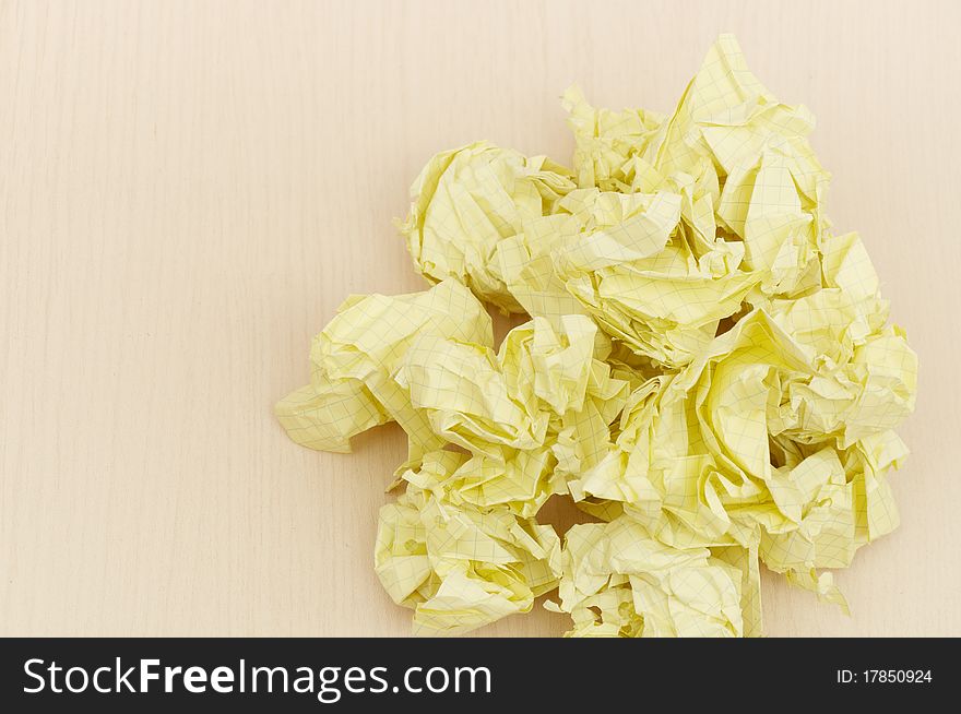 Yellow crumpled paper on wooden table background