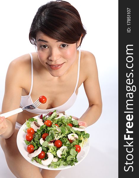Healthy Japanese girl looks up eating green salad