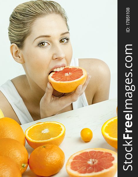 Portrait of young woman eating grapefruit