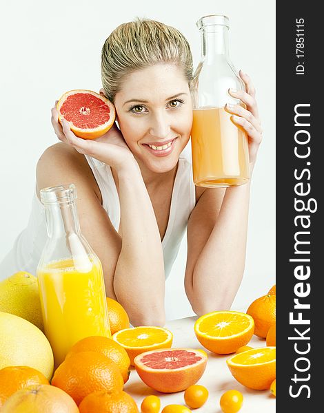 Portrait of young woman with citrus fruit and orange juice