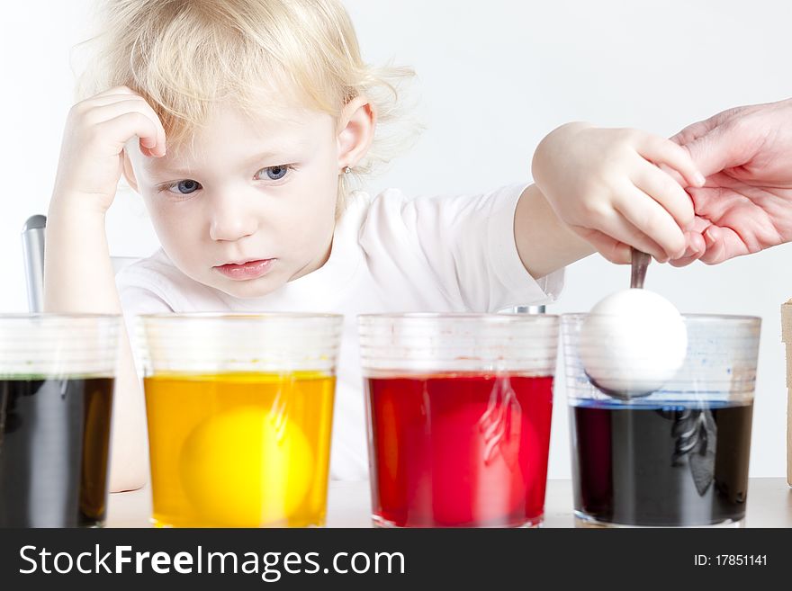 Little girl during Easter eggs' coloration