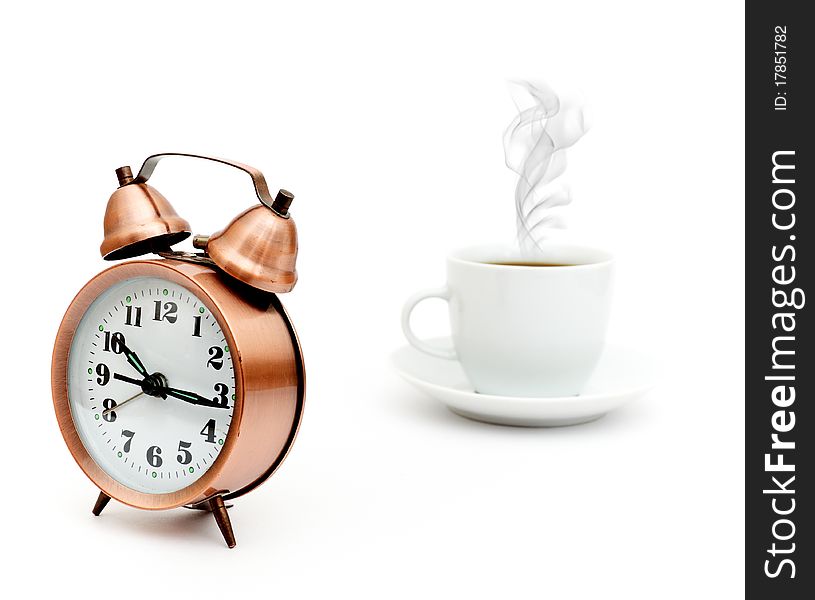 Vintage alarm clock and white coffee cup