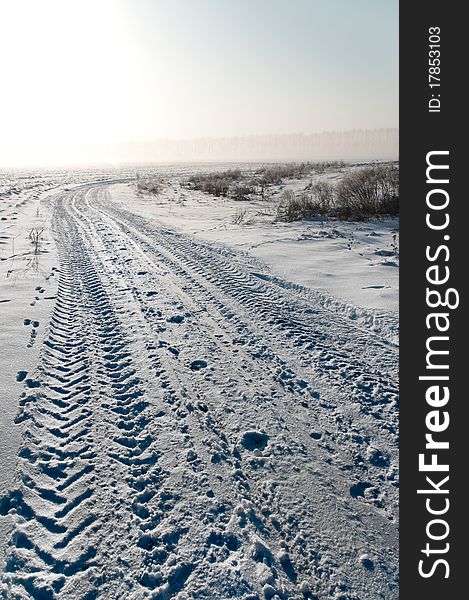 Traces of a tractor in the snow on the field road. Traces of a tractor in the snow on the field road