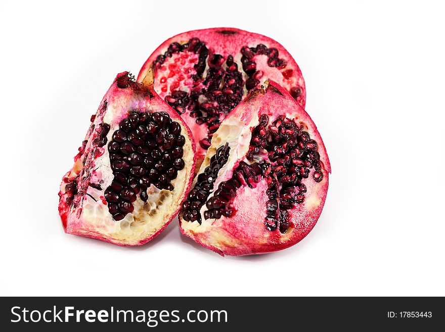 Pomegranate divided into parts isolated over white