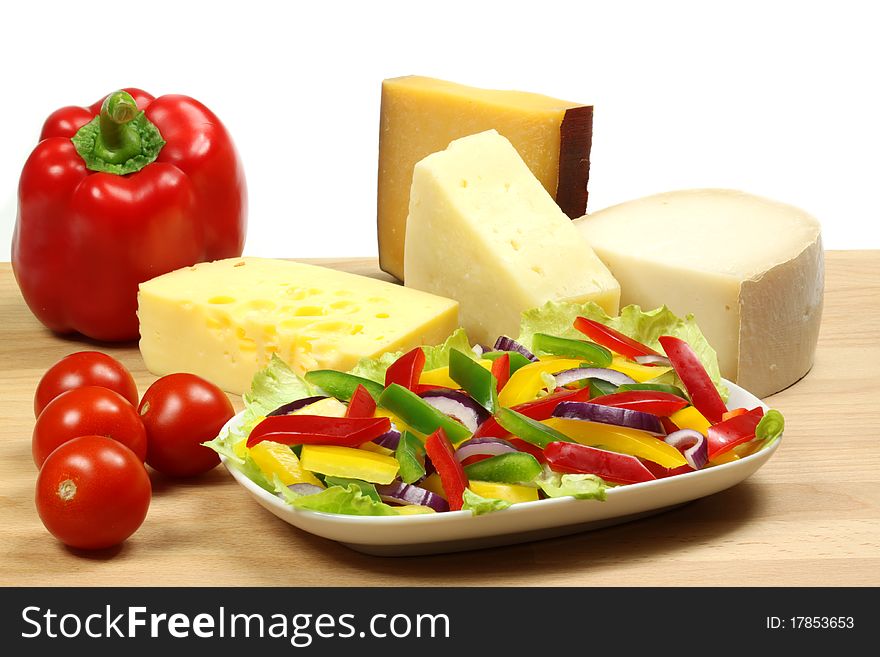 Fresh vegetable salad. Colorful organic cuisine. Onions, peppers and lettuce. Hard cheese in background. Fresh vegetable salad. Colorful organic cuisine. Onions, peppers and lettuce. Hard cheese in background.