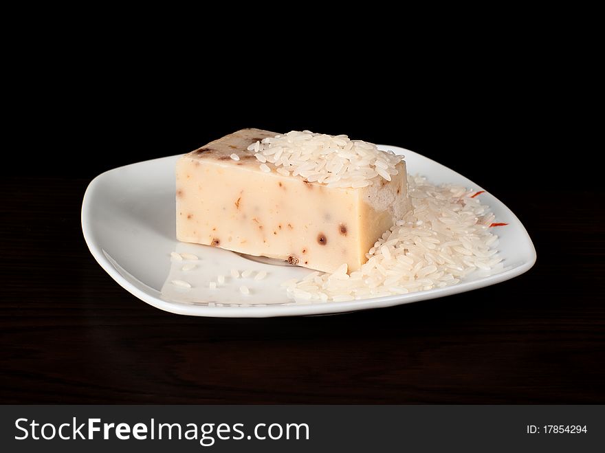 A piece of handmade soap with rice on the plate. A piece of handmade soap with rice on the plate.